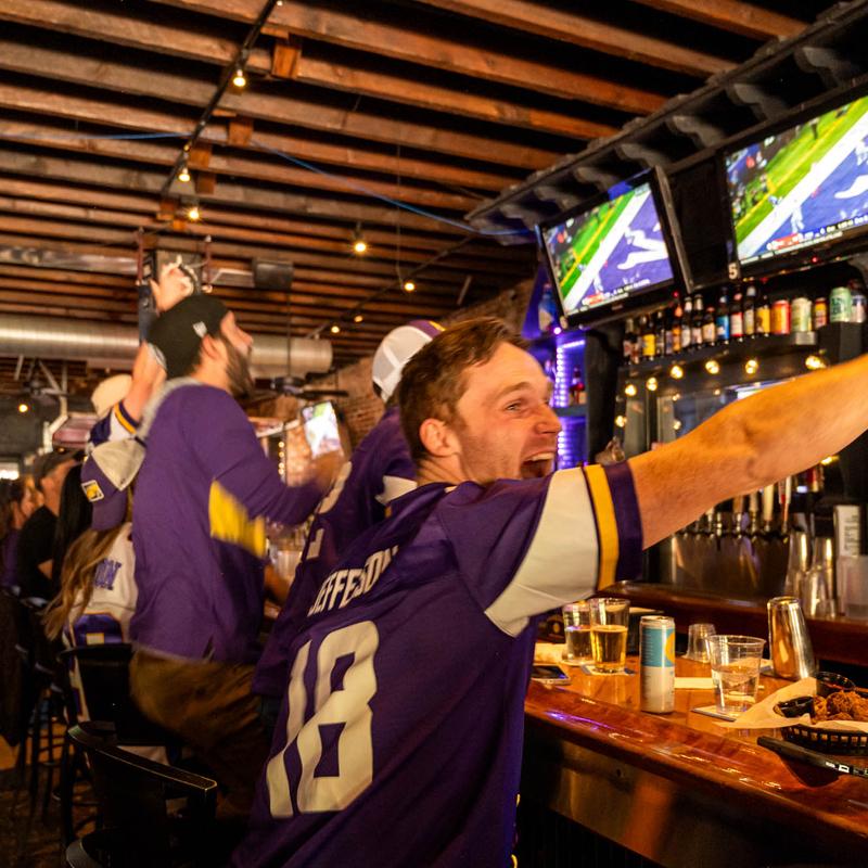 Customers watching a game and cheering.