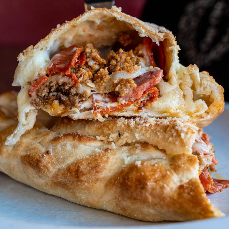 Calzone, withsausage, salami, capicola, marinara, mozzarella, goat cheese, parmesan, and basil.